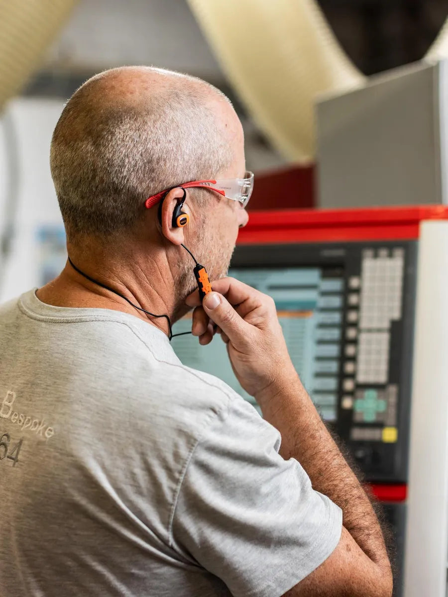 Vakman met de ISOtunes PRO 3.0 aan een machine